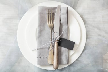 Tatil yemek. Tabaklar, gümüş çatal ve bıçak ve boş siyah etiket, metin için yer yer sofra