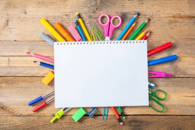 Geri okul kavramı. Okul malzemeleri ve ahşap arka plan, metin için yer üstünde boş defter görünümü top