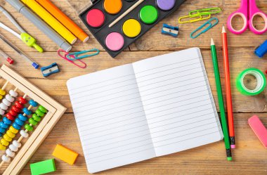 Geri okul kavramı. Okul malzemeleri ve ahşap arka plan, metin için yer üstünde boş defter görünümü top