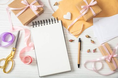 Kız vaftiz ve olay davetiyeleri hazırlık. Boş bir not defteri ve davetiyeleri bir beyaz tahta masa, kopya alanı üzerinde düz lay ve en iyi görünümü.