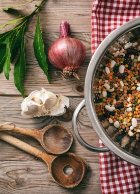 Sağlıklı yemek. Karışık baklagiller, otlar ve ahşap masa, üstten görünüm üzerinde kırmızı masa örtüsü
