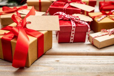 Noel hediye kutuları kırmızı şeritler ve boş Etiketler ahşap arka planda, kopya alanı