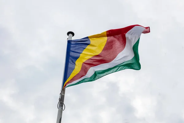 Seychellernas Flagga Stolpe Som Viftar Molnig Himmel Bakgrund — Stockfoto