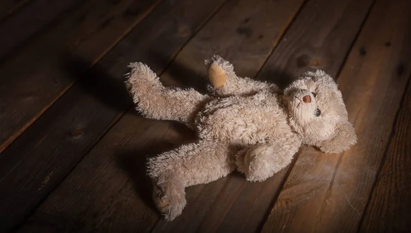 Conceito Abuso Infantil Teddy Urso Deitado Chão Fundo Madeira Escura — Fotografia de Stock