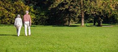 Şehir Parkı, sonbahar, Münih, Almanya. Olgun çift çimen, Web sitesi banner yürüyüş görünümünü