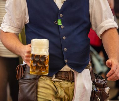 Oktoberfest, Münih, Almanya. Garson bir bira, closeup görünümü tutan geleneksel kostüm