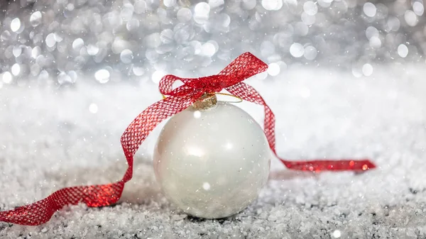 Boże Narodzenie Biały Ball Czerwoną Wstążką Śnieg Bokeh Streszczenie Tło — Zdjęcie stockowe