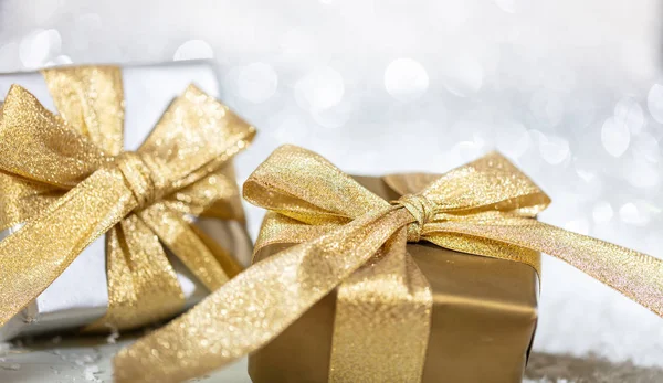 圣诞礼品盒与金色丝带上抽象的 Bokeh 灯和闪闪发光的背景 复制空间 — 图库照片