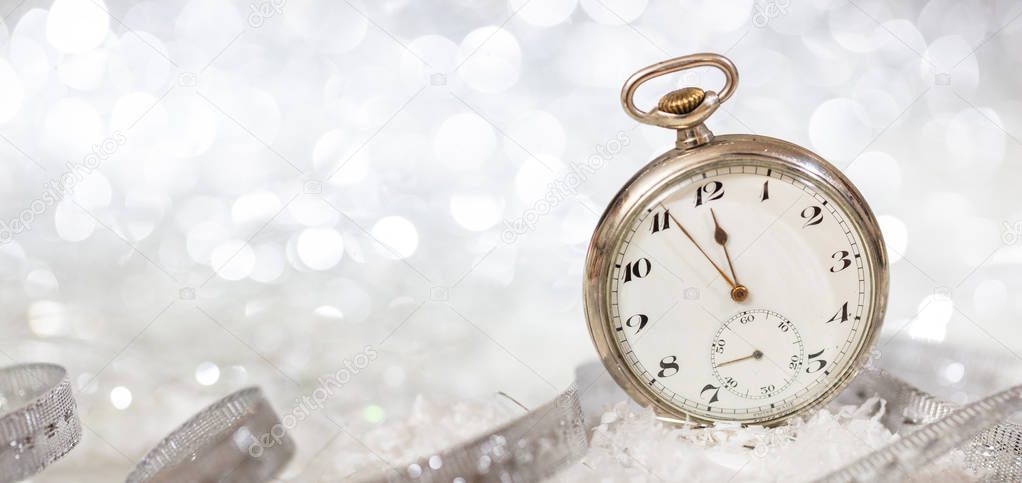 New Years eve party celebration. Minutes to midnight on an old fashioned watch, bokeh festive background, banner