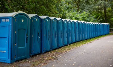 Parkta portatif tuvalet-kabinler. Bir satır bir orman arka plan bir festival için kimyasal tuvalet