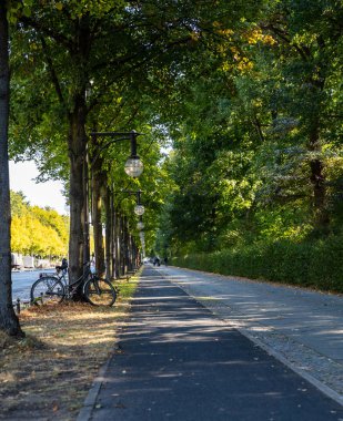 Siyah Bisiklet park etmiş bir boş Bisiklet lane, Berlin, ağaçta karşı duvar kağıdı.