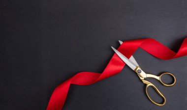 Büyük açılış. Altın Makas siyah arka plan, kopya alanı karşı kırmızı ipek kurdele kesme üstten görünüm