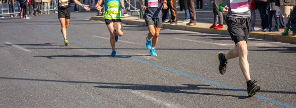 Marathon running race, group of runners on city roads, detail on legs, banner