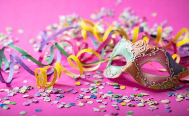 Karnaval parti. Renkli maske, flamalar ve parlak pembe arka plan üzerine konfeti, 