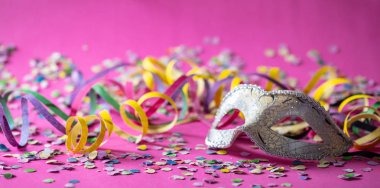 Karnaval parti. Beyaz Gümüş maskesi, flamalar ve konfeti parlak pembe arka plan üzerinde afiş
