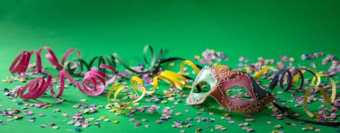 Karnaval parti. Banner renkli maskesi, flamalar ve parlak yeşil zemin üzerine konfeti