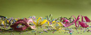 Karnaval parti. Pembe maske, flamalar ve konfeti yeşil arka plan üzerinde başlık sayfası