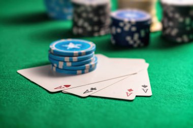 Casino, bahis, kavram. Dört as ve yeşil keçe zemin üzerine poker fişleri