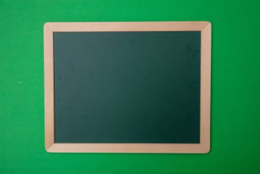 Yeşil boş boş tebeşir tahtası ahşap çerçeve, yeşil duvar arka plan ile. Metin için yer