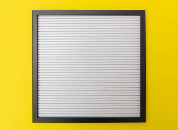 白い空空盤黒フレーム 黄色い壁の背景です テキストのためのスペース — ストック写真