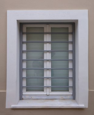 Bej renk duvar arka plan, eski şehir, Plaka içinde Atina Yunanistan bina konut üzerinde gri metal çubuklarla Beyaz ahşap pencere