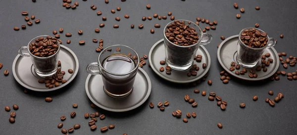 Coffee time. Coffee and coffee beans in glass cups with sausers, on black color background