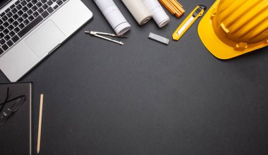 Mimar mühendis inşaat site Ofis Masası. Proje planları, Sarı Sabit hat ve bilgisayar dizüstü siyah renk, üstten görünüm, kopya alanı