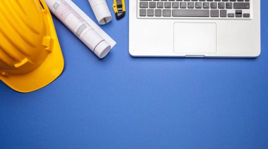 Mimar mühendis inşaat site Ofis Masası. Proje planları, Sarı Sabit hat ve bilgisayar dizüstü mavi renk, üstten görünüm, kopya alanı