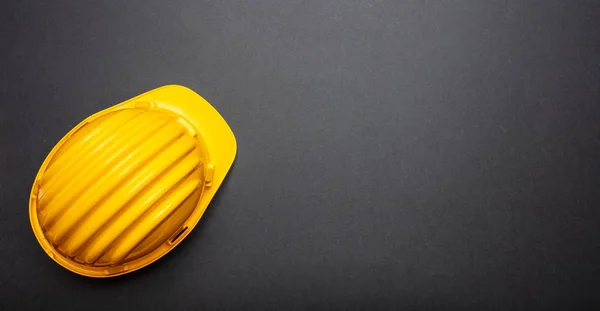 建设项目安全 黑色背景黄色安全帽 复制空间 顶视图 — 图库照片