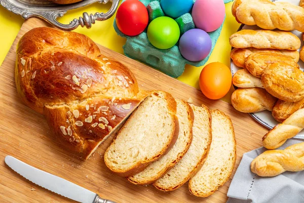 Huevos de Pascua y trenza tsoureki, pan dulce griego de Pascua, sobre madera — Foto de Stock