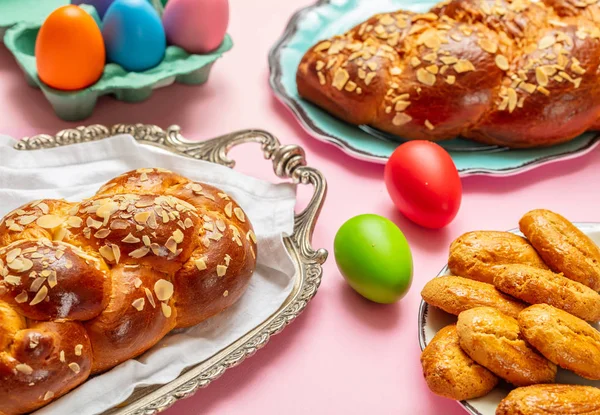 Huevos de Pascua y trenza tsoureki, pan dulce griego de Pascua, sobre fondo de color rosa —  Fotos de Stock