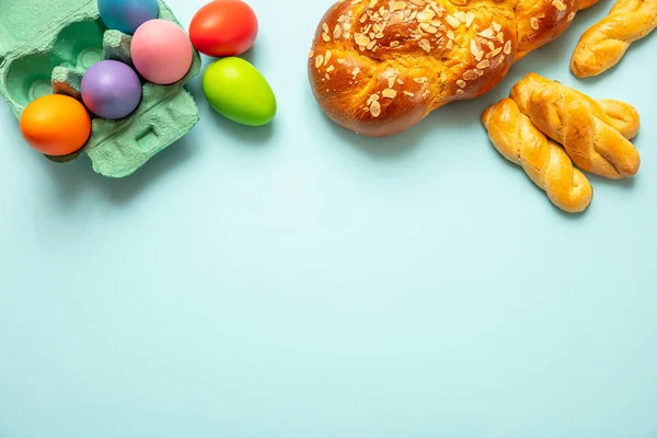 Easter eggs and tsoureki braid, greek easter sweet bread, on blue background