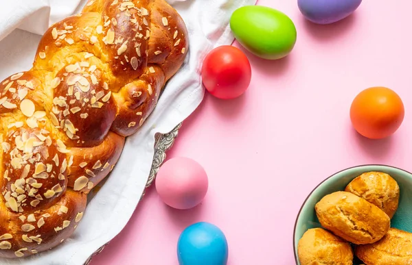 Huevos de Pascua y trenza tsoureki, pan dulce griego de Pascua, sobre fondo de color rosa —  Fotos de Stock