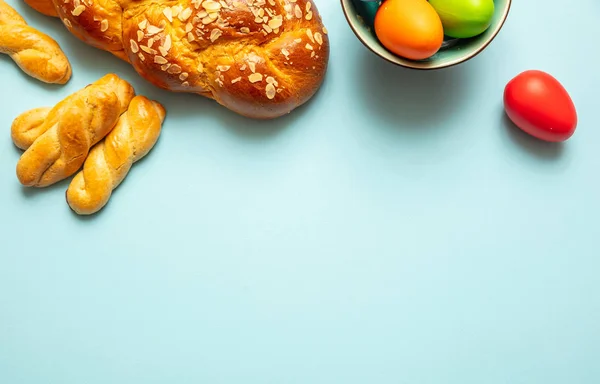 Huevos de Pascua y trenza tsoureki, pan dulce griego de Pascua, sobre fondo azul —  Fotos de Stock
