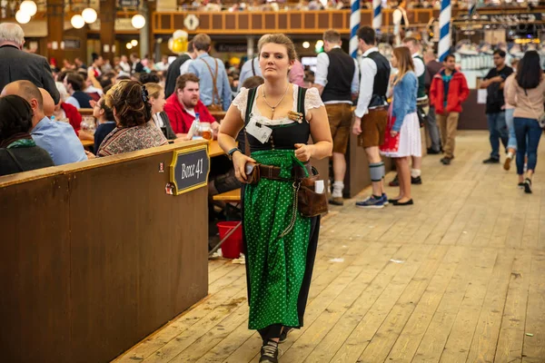 Múnich, Alemania, Oktoberfest, camarera en traje tirolés sosteniendo cervezas, fondo interior de la tienda —  Fotos de Stock