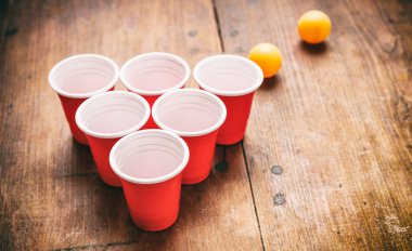 Bira pong. Plastik kırmızı renk bardak ve ping pong topları ahşap arka plan üzerinde