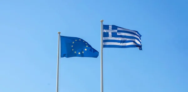 Греція та ЄС. Грецькому та Європейському Союзі прапори махав на чисте блакитне небо — стокове фото