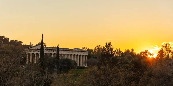 Atenas Grecia. Templo de Hefesto al amanecer, sol levantándose contra el cielo de color naranja —  Fotos de Stock