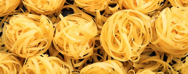 Fettuccine crude nido pasta texture sfondo, banner — Foto Stock