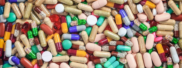 Medicina, medicación. Coloridas pastillas y cápsulas de fondo, banner — Foto de Stock