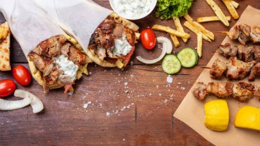 Gyro pide, shawarma, souvlaki. İki pide ekmek tamamladı ve et şiş ahşap tablo