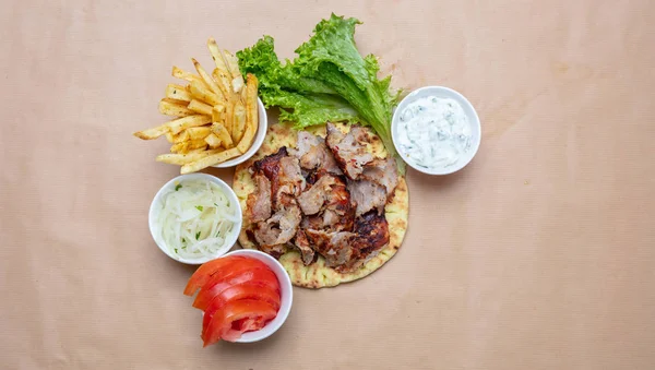 Shawarma, gyron på pitabröd, grönsaker och tzatziki sås, ovanifrån. Traditionella turkiska, grekiska meatmaten. — Stockfoto