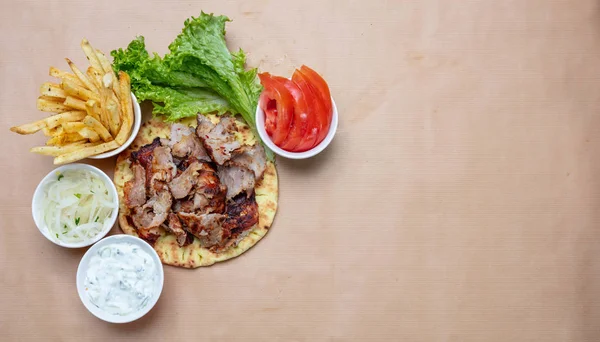 Shawarma, gyron på pitabröd, grönsaker och tzatziki sås, ovanifrån. Traditionella turkiska, grekiska meatmaten. — Stockfoto