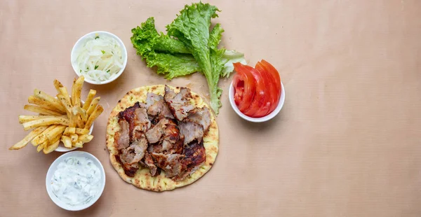 Shawarma, gyron på pitabröd, grönsaker och tzatziki sås, ovanifrån. Traditionella turkiska, grekiska meatmaten. — Stockfoto