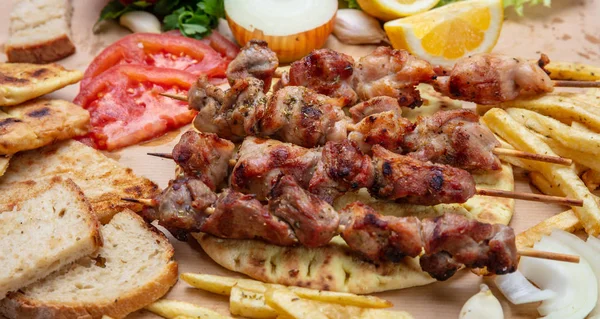 Сувлаки, мясные шашлыки, традиционная греческая турецкая мясная еда на пита-хлебе, соус цацики и картофель — стоковое фото