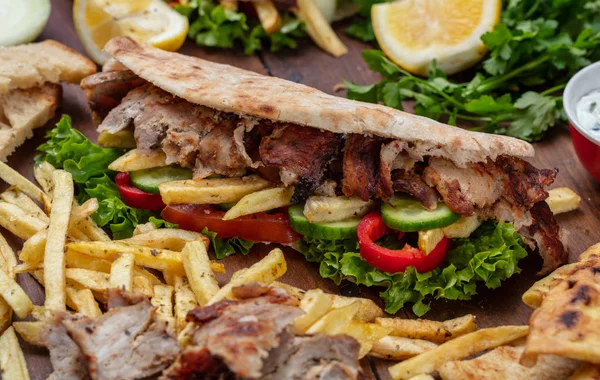 Gyros, shoarma, wegnemen, straatvoedsel. Sandwich met vlees op houten tafel — Stockfoto