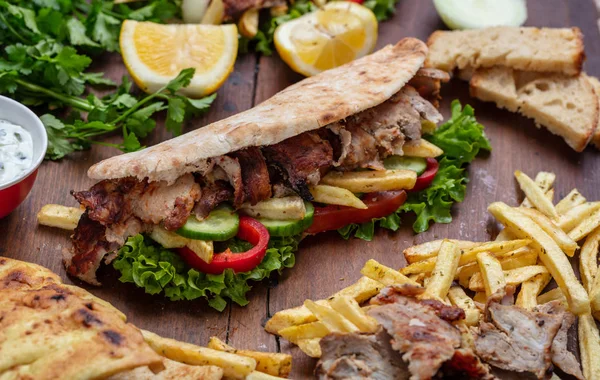 Gyros, shoarma, wegnemen, straatvoedsel. Sandwich met vlees op houten tafel — Stockfoto