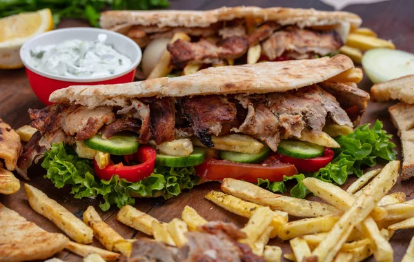 Gyros, shawarma, take away, street food.  Sandwich with meat on wooden table