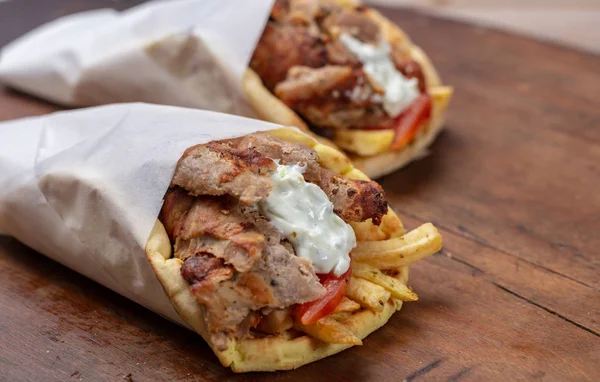 Gyro pita, shawarma, comida callejera. Griego tradicional turco, comida de carne en la mesa de madera — Foto de Stock