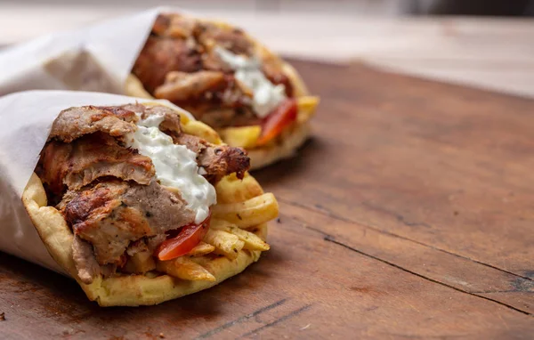 Gyro pita, shawarma, comida callejera. Griego tradicional turco, comida de carne en la mesa de madera — Foto de Stock